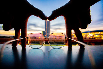 Close-up of silhouette hand against sky during sunset