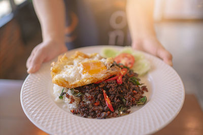 Spicy basil stir-fried beef and rice in a ceramic plate