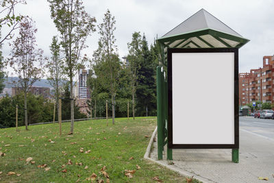 Gazebo in park by buildings against sky in city