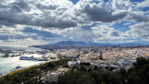 High angle view of city by sea against sky