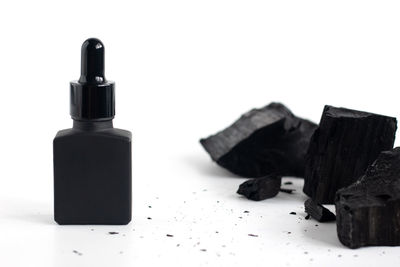 Close-up of coins on bottle against white background