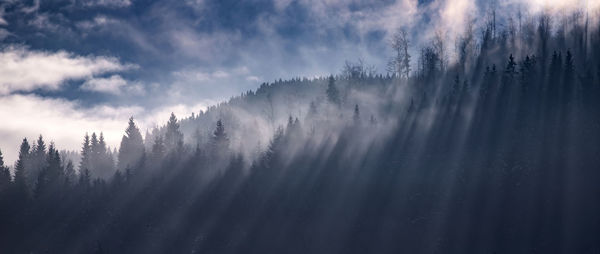 Panoramic view of snow covered mountains against sky