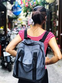 Woman tourist is looking for the accommodation in vietnam. rear view of women standing in city