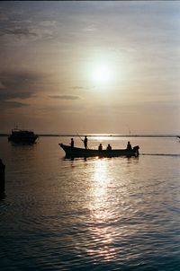 Silhouette boats in sea against sky during sunset