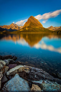 Scenic view of lake and mountains against blue sky