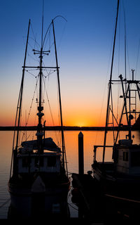 Silhouette ship on sea against romantic sky at sunset