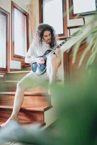 Man playing guitar at home