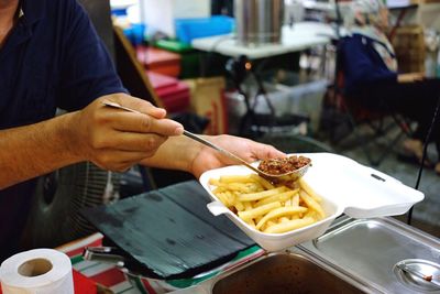 Cropped hands of man having food