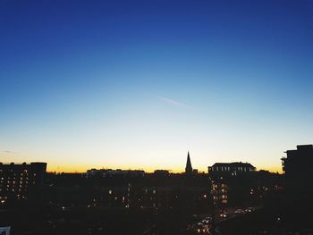 Illuminated city against clear sky