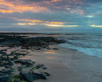 Scenic view of beach against sky during sunset