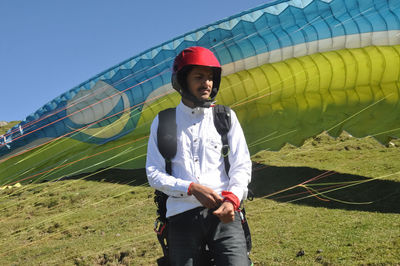 A north indian young guy looking sideways while preparation of paragliding flight. 