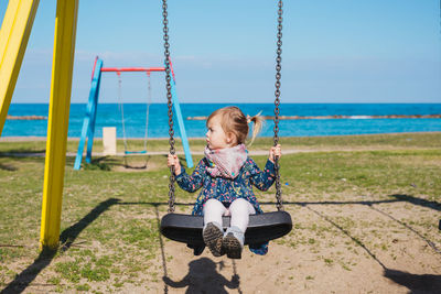 Girl sitting on swing at playground