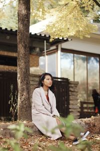 Full length of woman standing by tree