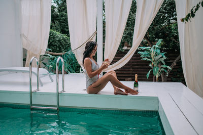 Woman sitting in swimming pool