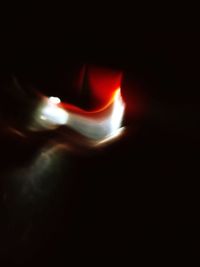 Close-up of lit candle against black background