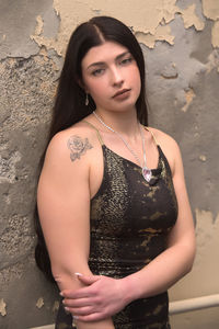 Portrait of woman standing against wall