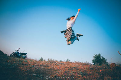 Low angle view of person paragliding against clear blue sky