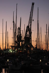 Boats moored at harbor against sky during sunset