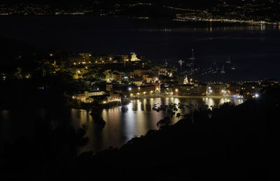 High angle view of illuminated buildings by river at night