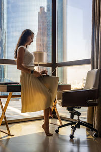 Rear view of woman looking through window