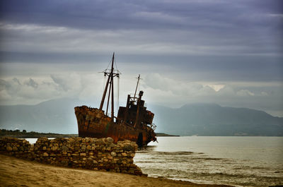 Sailboat on sea shore against sky