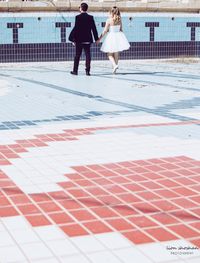 Rear view of people walking on swimming pool