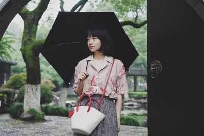 Woman looking away while standing outdoors