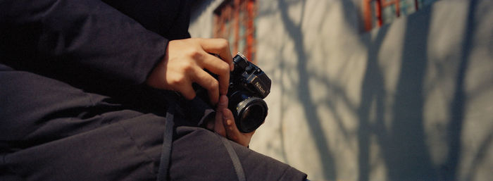 Low section of man holding camera