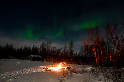 Scenic view of snow covered land against sky at night