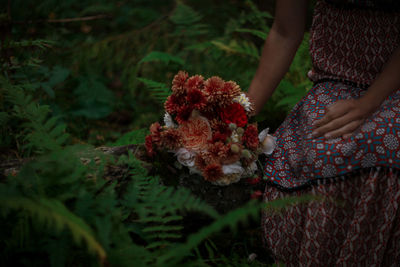 Midsection of woman holding flower bouquet