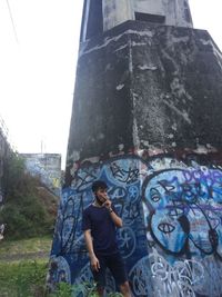 Full length of young man standing against wall