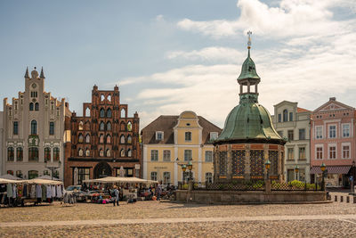 View of buildings in city against cloudy sky