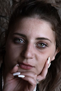 Close-up portrait of young woman with green eyes