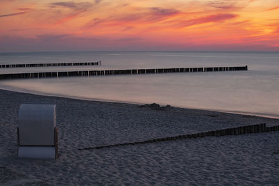 Pier over sea against sky during sunset