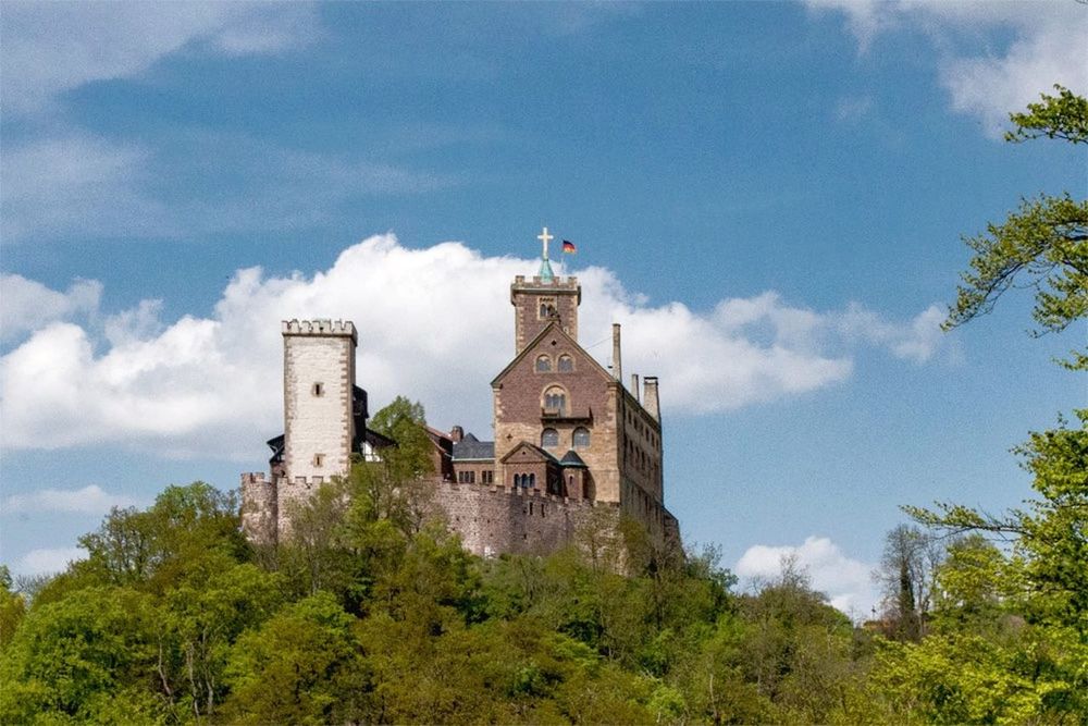 architecture, built structure, building exterior, sky, tree, low angle view, cloud - sky, religion, cloud, church, tower, place of worship, spirituality, blue, green color, day, history, castle, nature