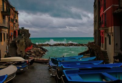 Boats moored on sea against buildings in city