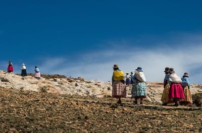 Rear view of people walking on landscape
