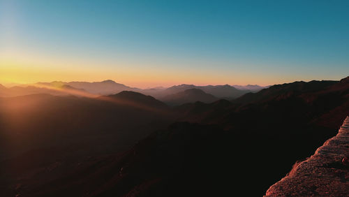 Scenic view of mountains against clear sky during sunset