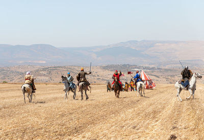 Group of people riding horses on land