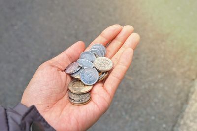 Close-up of hand holding coins