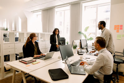 Professionals discussing over sales strategies at work place