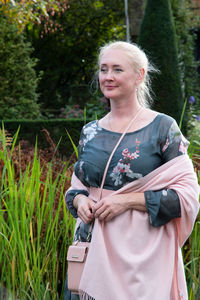 Young beautiful woman in a long dress with a floral print and a pink shawl