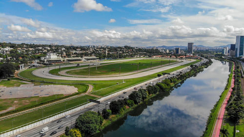 High angle view of city by river against sky