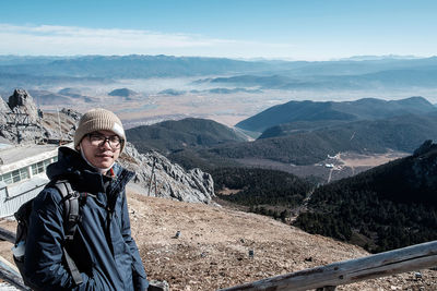 Portrait of man standing on mountain during winter