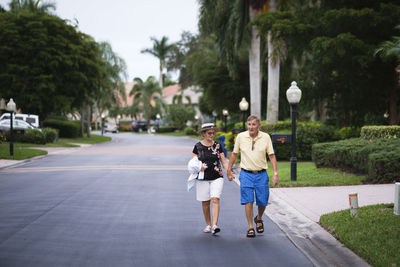 Rear view of two women walking on road
