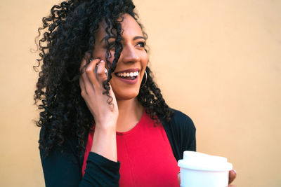 Portrait of smiling young woman using mobile phone