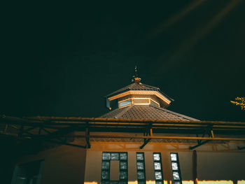 Low angle view of illuminated building against sky at night