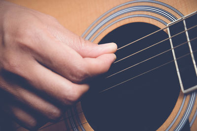 Midsection of person playing guitar