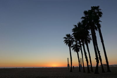 Scenic view of coconut palm trees on beach against clear sky