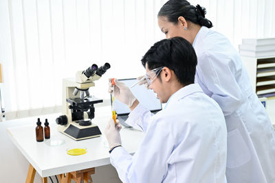 Female doctor examining chemical in laboratory